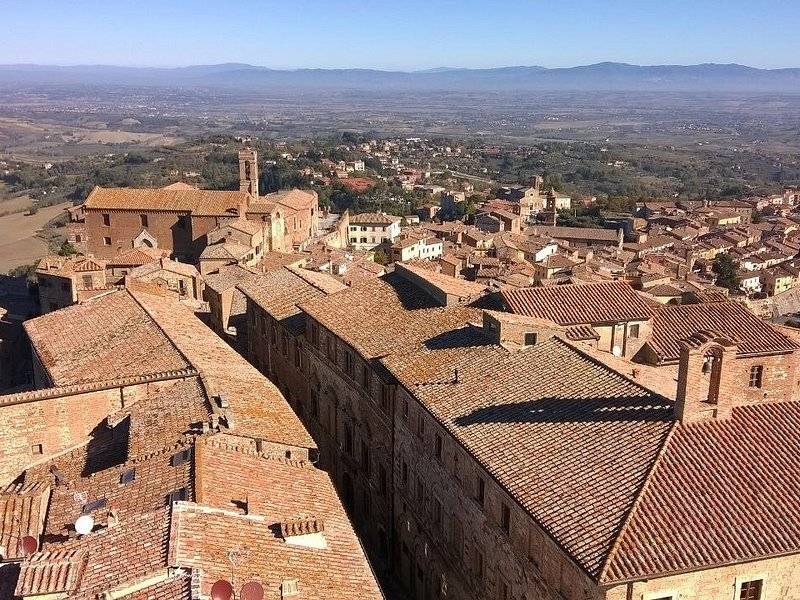 Montepulciano's tiled roofs from above, the Valdichiana running out to the hills beyond
