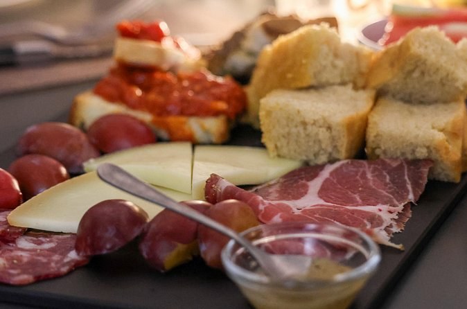 A board of cured meats, cheese and bread set out for a tasting